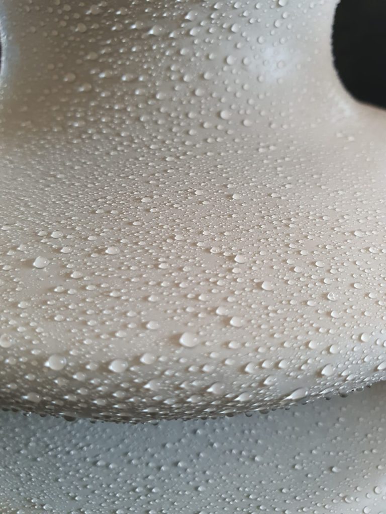 Close up of Si-Coat 570 HVIC showing water droplets beading on the silicone surface, demonstrating hydrophobicity and self cleaning properties