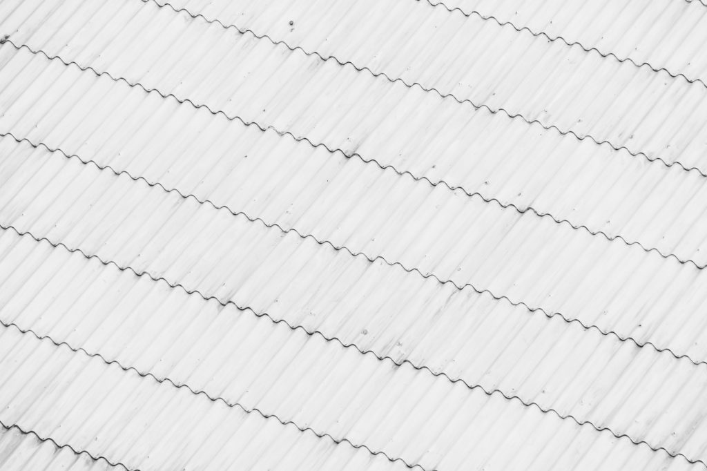 SI-Coat 461 silicone roof coating applied to a roof surface, reflecting sunlight to reduce heat build-up and help keep buildings cooler