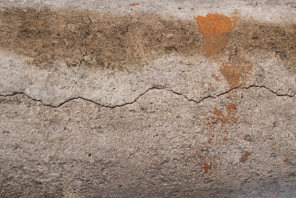 Concrete surface showing a movement crack at a joint caused by thermal expansion and structural movement.