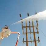 High‑voltage insulators undergoing live washing to remove surface contamination from electrical equipment.